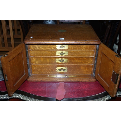 165 - Oak table part canteen of cutlery having double doors concealing four drawers with brass fittings, 5... 