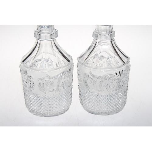 195 - Pair of Baccarat moulded body decanters and stoppers, 32cm high, one ill fitting stopper.