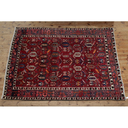 383 - Hand knotted Iranian wool carpet with a red ground, 2.66 by 2.00.