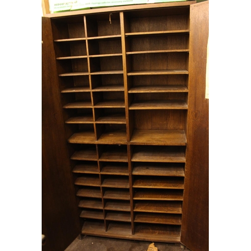 389 - Mid 20th Century oak Post Office two door sorting cupboard fitted with compartments. 189cm by 96cm b... 