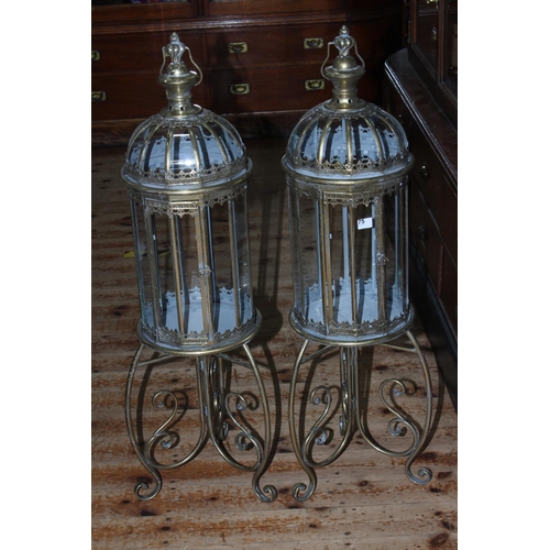 75 - Pair of gilt metal and glazed hall lanterns on ornate stands, 109cm  high.