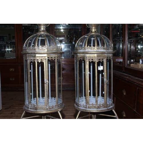 75 - Pair of gilt metal and glazed hall lanterns on ornate stands, 109cm  high.