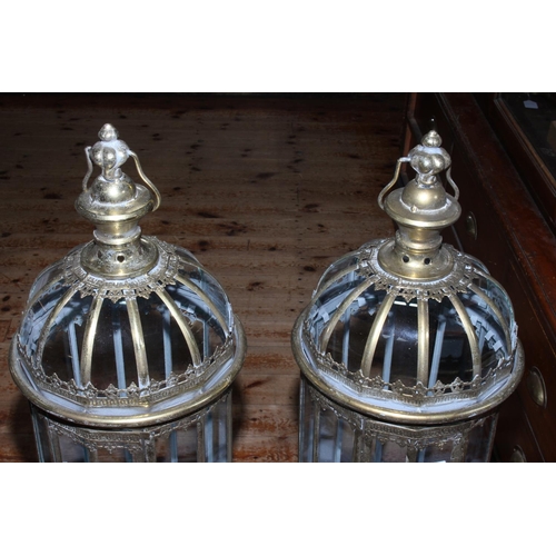 75 - Pair of gilt metal and glazed hall lanterns on ornate stands, 109cm  high.