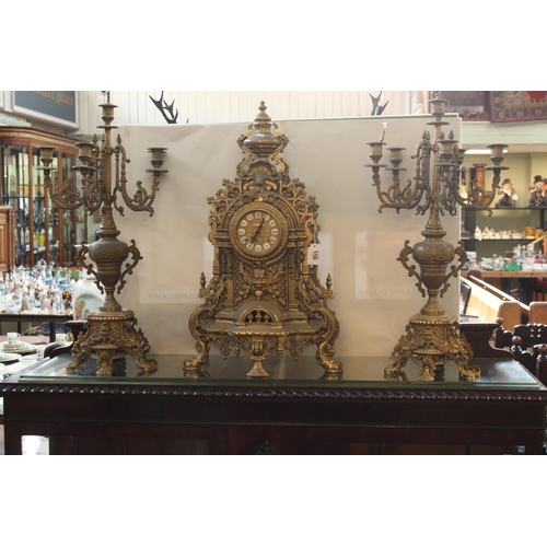 156 - Highly ornate brass clock set, candelabra 67cm high.