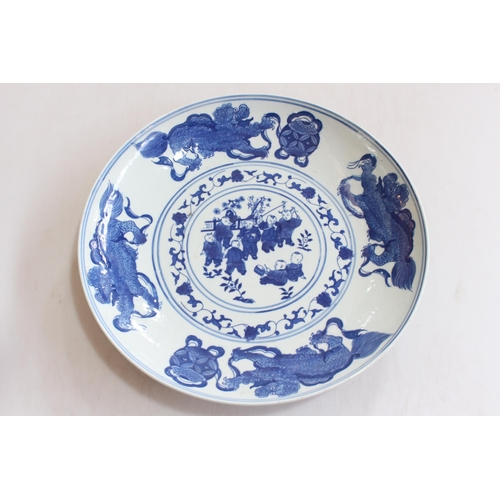 160 - Chinese blue and white saucer dish, decorated with children and dragon border, 29cm diameter.