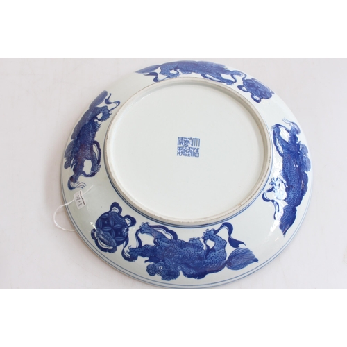 160 - Chinese blue and white saucer dish, decorated with children and dragon border, 29cm diameter.