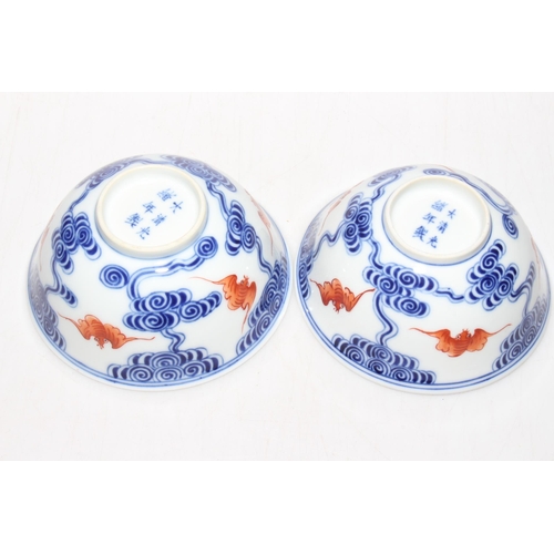 175 - Pair Chinese bowls with iron red bats and blue swirls, 12cm diameter, six character mark.