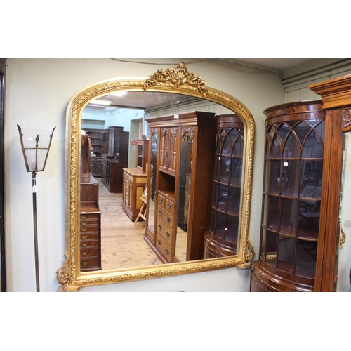 461 - Arched top gilt framed overmantel mirror with shell and floral crest, 158cm by 162cm.