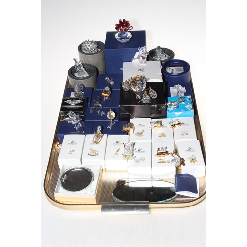 1 - Collection of mostly boxed Swarovski ornaments, and some mirrored stands.