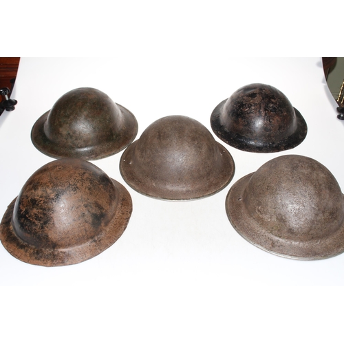 179 - Five metal military helmets.