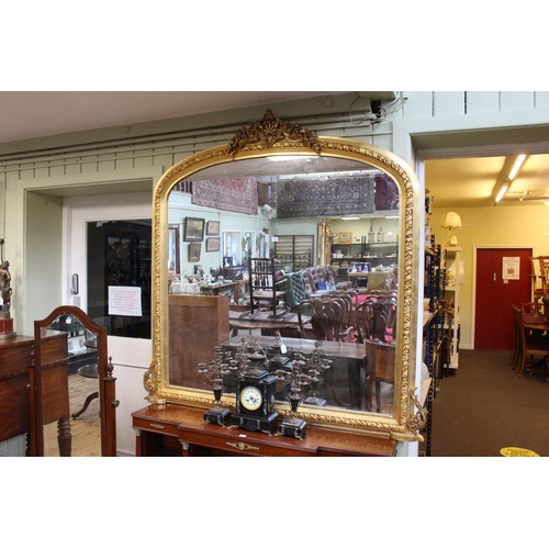 572 - Arched gilt framed overmantel mirror with floral and shell crest, 161cm by 160cm.