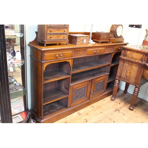 577 - Late Victorian mahogany cabinet bookcase having three drawers above open shelves and two carved pane... 