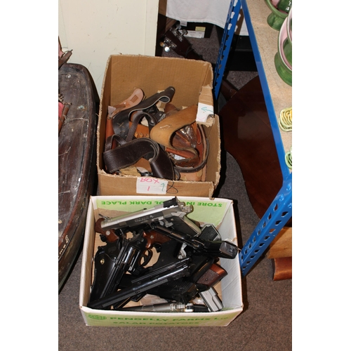 108 - Two boxes of air pistols, holsters, replica pistols, etc.