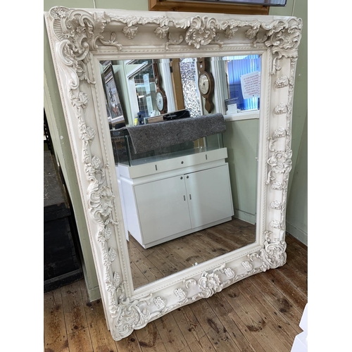 376 - Large white painted ornate framed bevelled wall mirror, 156cm by 126cm including frame.