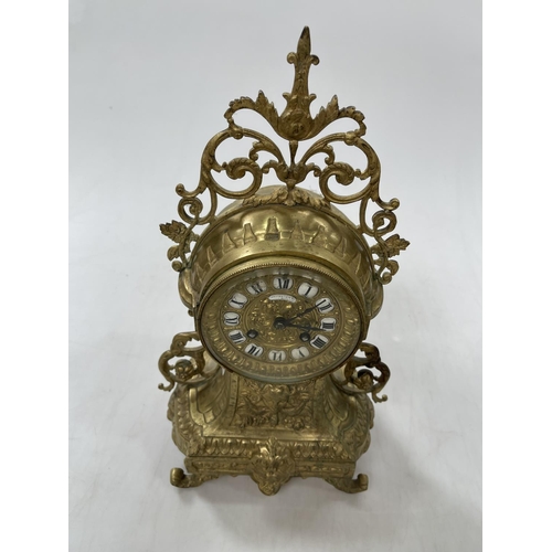 146 - Ornate gilt metal mantel clock with cherub face column named 'Lambert Levy', 38cm high.