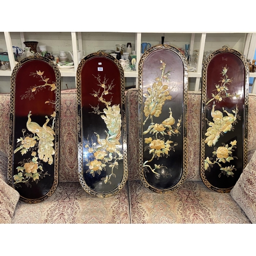 352 - Set of four Oriental lacquered panels with applied bird and floral decoration.