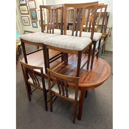 390 - Oval rosewood extending dining table and eight chairs.