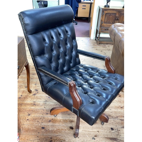 437 - Black deep buttoned leather swivel office armchair.