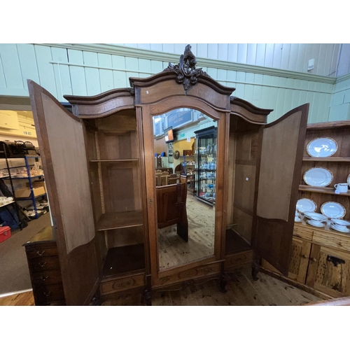 483 - French oak breakfront armoire having central mirror door flanked by two mirror panelled doors above ... 