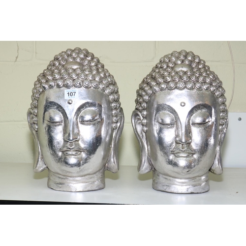 107 - Pair of silvered Buddha heads.