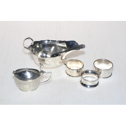 245 - Silver sauce boat with silver serving spoon, silver lidded mustard pot, and three silver napkin ring... 