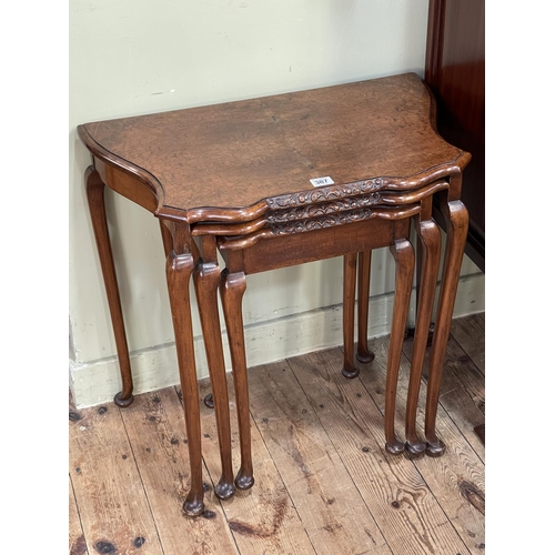 387 - Burr walnut nest of three shaped tables on cabriole legs (largest 58cm by 61cm by 37cm).