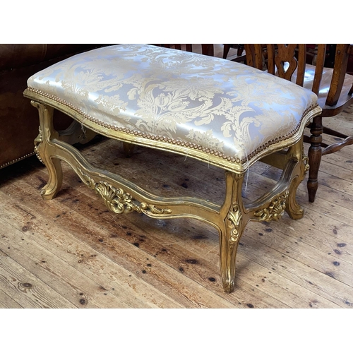 391 - Large gilt stool of serpentine form, 62cm by 107cm by 73cm.