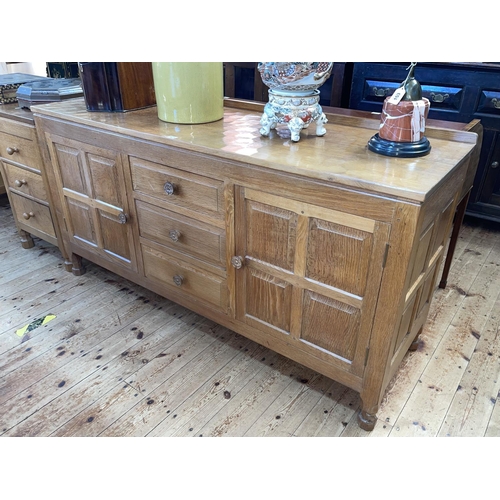 423 - Don Craven 'Foxman' adzed oak sideboard having three central drawers flanked by two cupboard doors, ... 