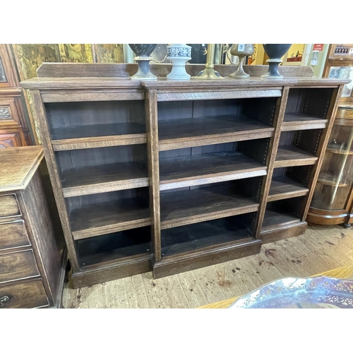 427 - 1920's/30's oak breakfront open bookcase with nine adjustable shelves, 129cm by 183.5cm by 37cm.