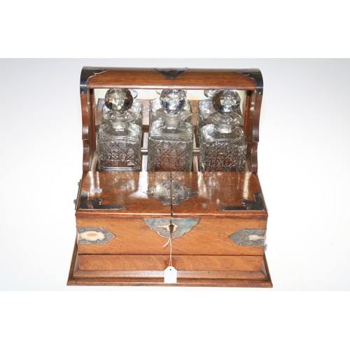 109 - Vintage oak three bottle tantalus with key, 33cm high.