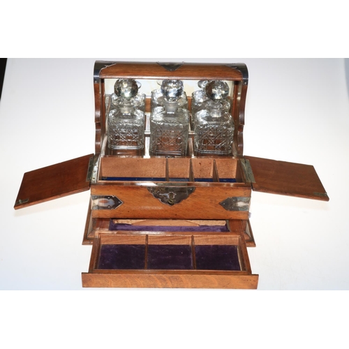 109 - Vintage oak three bottle tantalus with key, 33cm high.