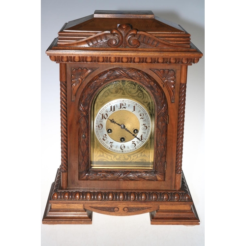 112 - A large mahogany mantel clock on bracket feet, having arched dial, 48cm high.