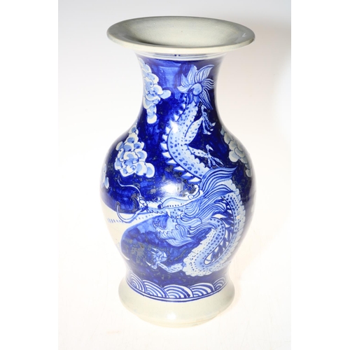 136 - Large blue and white vase decorated with mythical dragon and floral design, 30cm high.