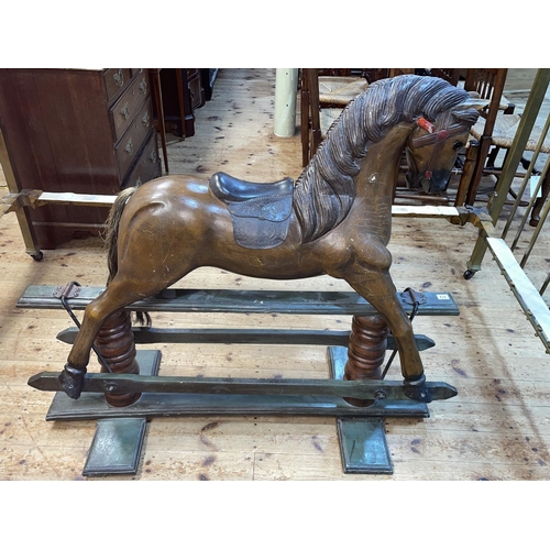 372 - Painted wooden rocking horse on safety stand, 105cm by 124cm.