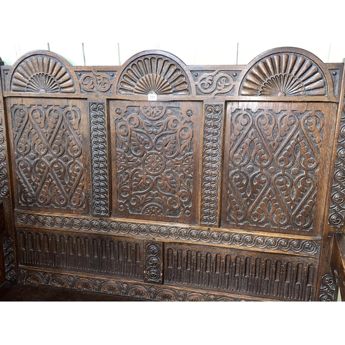 391 - 19th Century carved oak triple arched panel back box settle, 143cm by 136.5cm by 71cm.