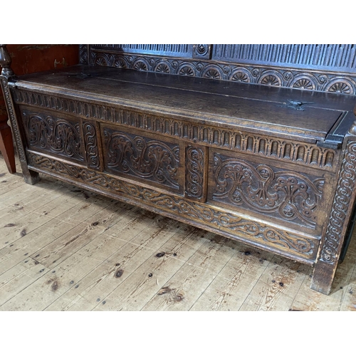 391 - 19th Century carved oak triple arched panel back box settle, 143cm by 136.5cm by 71cm.