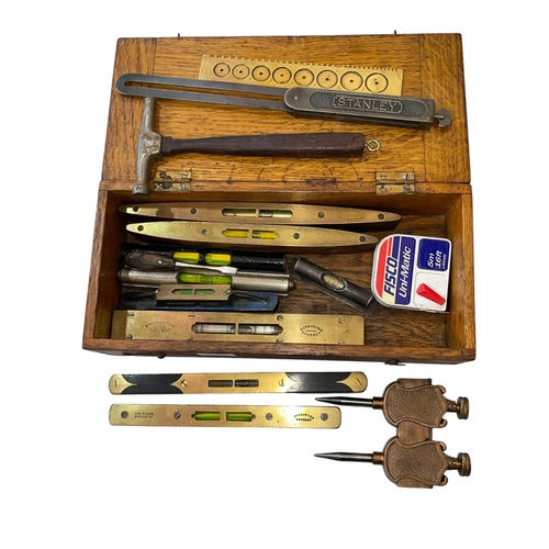 245 - Oak box with vintage spirit levels, mainspring gauge, etc.