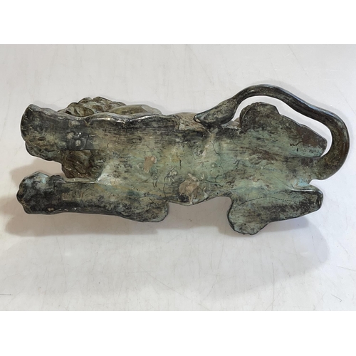 154 - Hollow bronze sculpture of a recumbent lion, 26cm long.