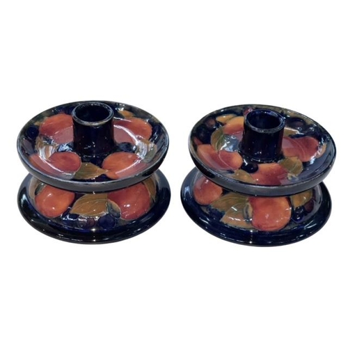 283 - Pair Moorcroft Pomegranate dwarf candlesticks, 12.5cm diameter.