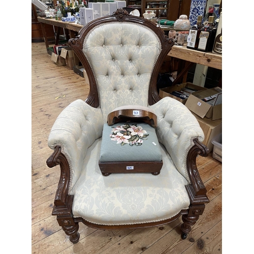 369 - Victorian carved walnut framed armchair and two floral needlework footstools.