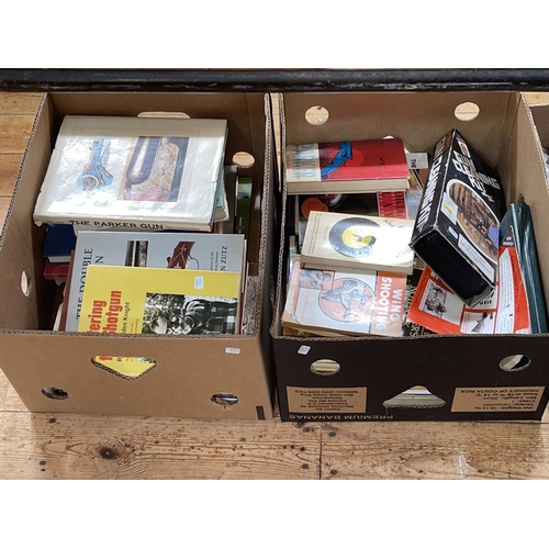 31 - Two boxes of shooting related books, .22 calibre rifle cleaning kit, etc.