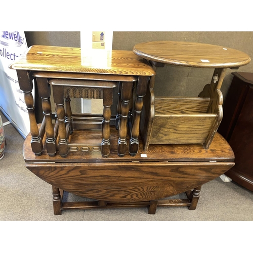 313 - Oval oak drop leaf coffee table, nest of three oak tables and oak magazine table (3).