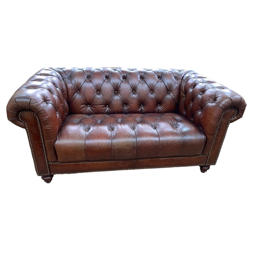 379 - Brown buttoned leather and studded two seater Chesterfield settee.