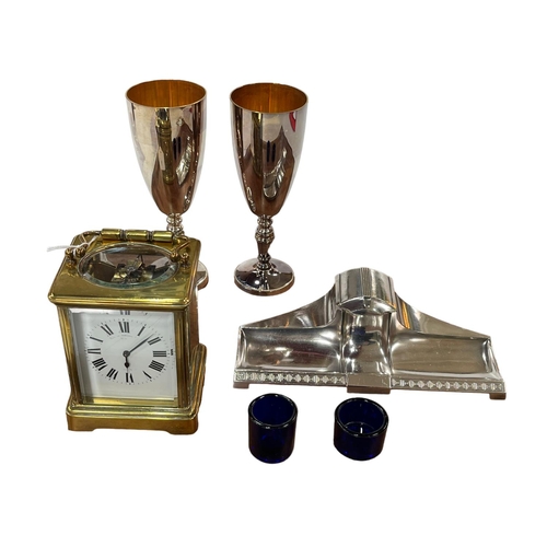 4 - French gilt brass carriage clock, Arts & Crafts inkstand, pair goblets and two blue glass liners.