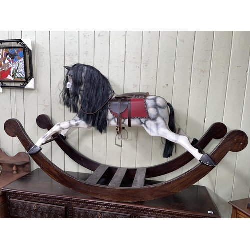 409 - Sponge painted rocking horse with leather saddle, 102cm by 176cm.