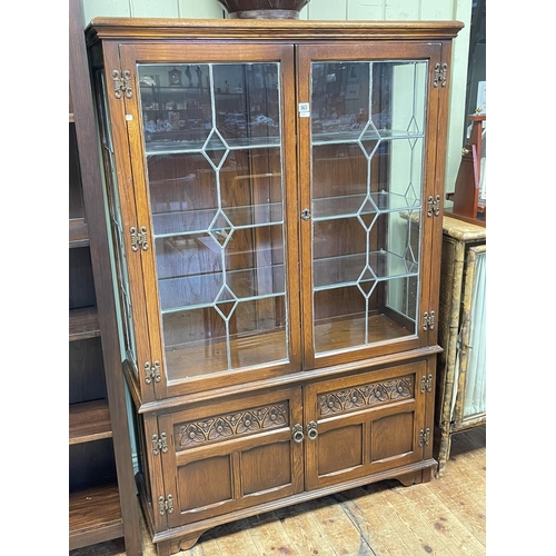 363 - Old Charm display cabinet having two leaded glazed doors above two carved panel doors, 161cm by 107.... 