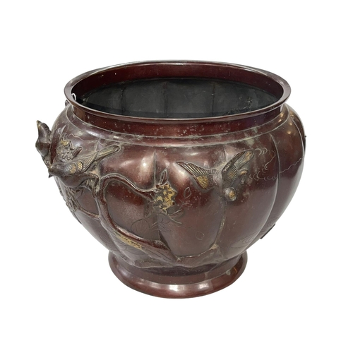 56 - Ornate Oriental bronze jardiniere decorated with raised birds on branch on fluted body, 29cm high.