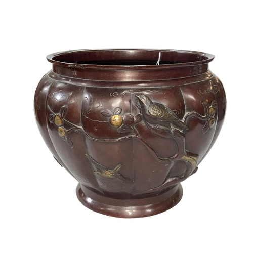 56 - Ornate Oriental bronze jardiniere decorated with raised birds on branch on fluted body, 29cm high.