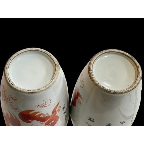 137 - Pair of Chinese Alum Red Fu dog decorated vases, 27.5cm.