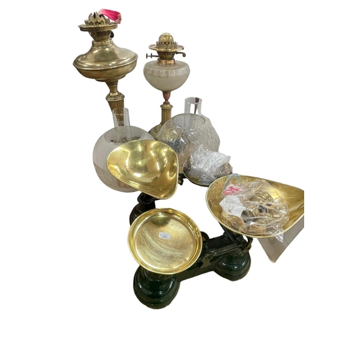 24 - Two brass oil lamps with frosted and clear glass shades and two sets of kitchen scales and weights.